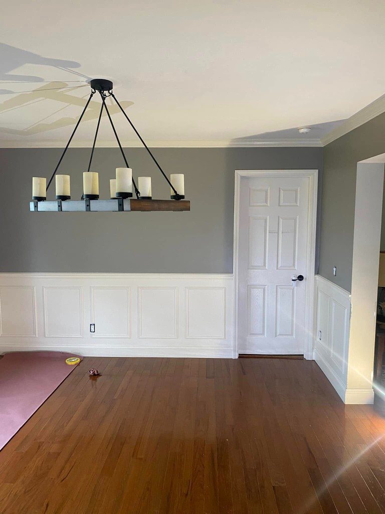 Interior room with gray walls, white wainscoting, and fresh trim paint