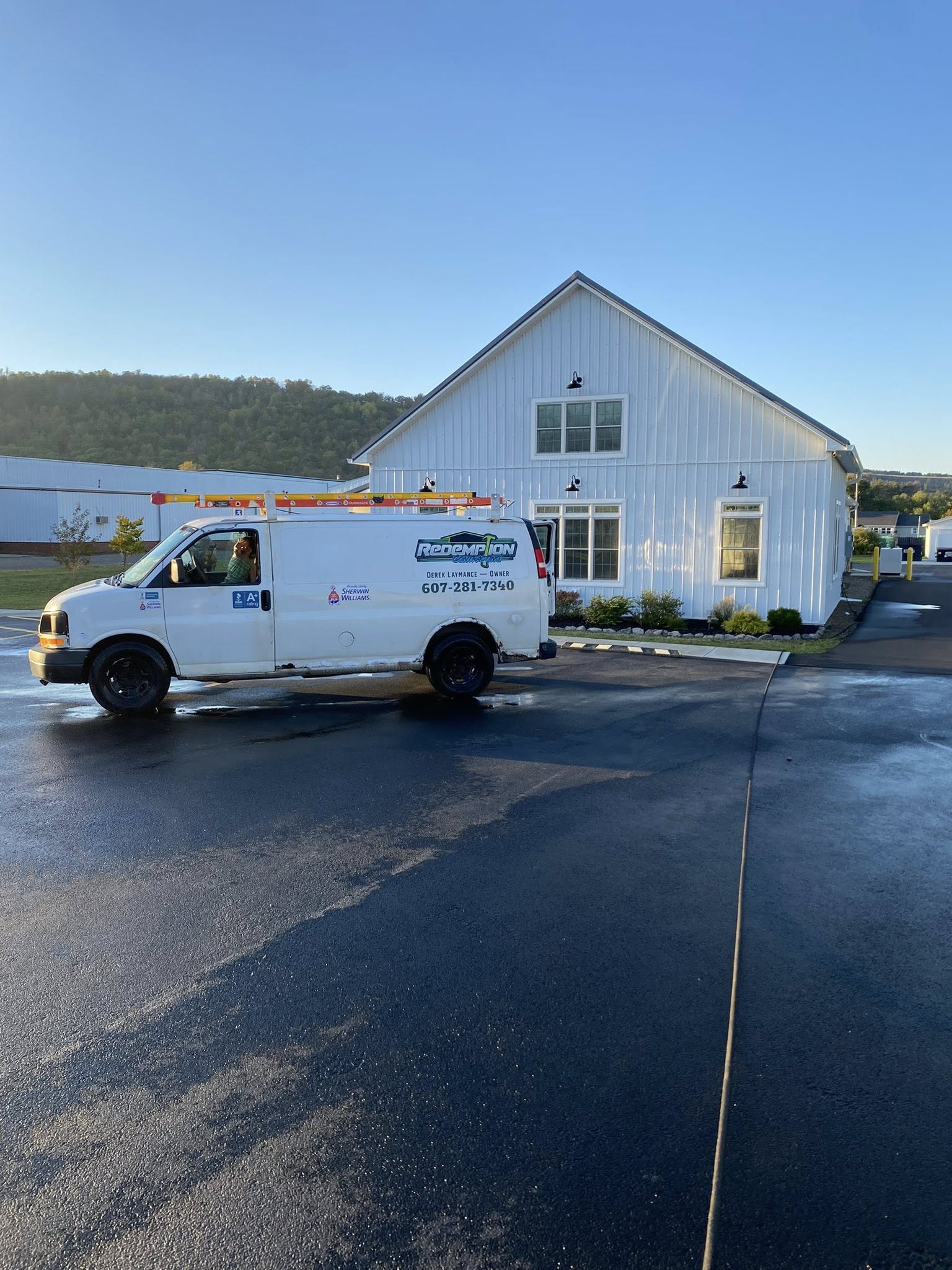 Redemption Contracting branded work van with ladder rack and company logo